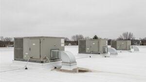 Three commercial rooftop HVAC package units on the flat membrane roof of a small retail building in upstate New York